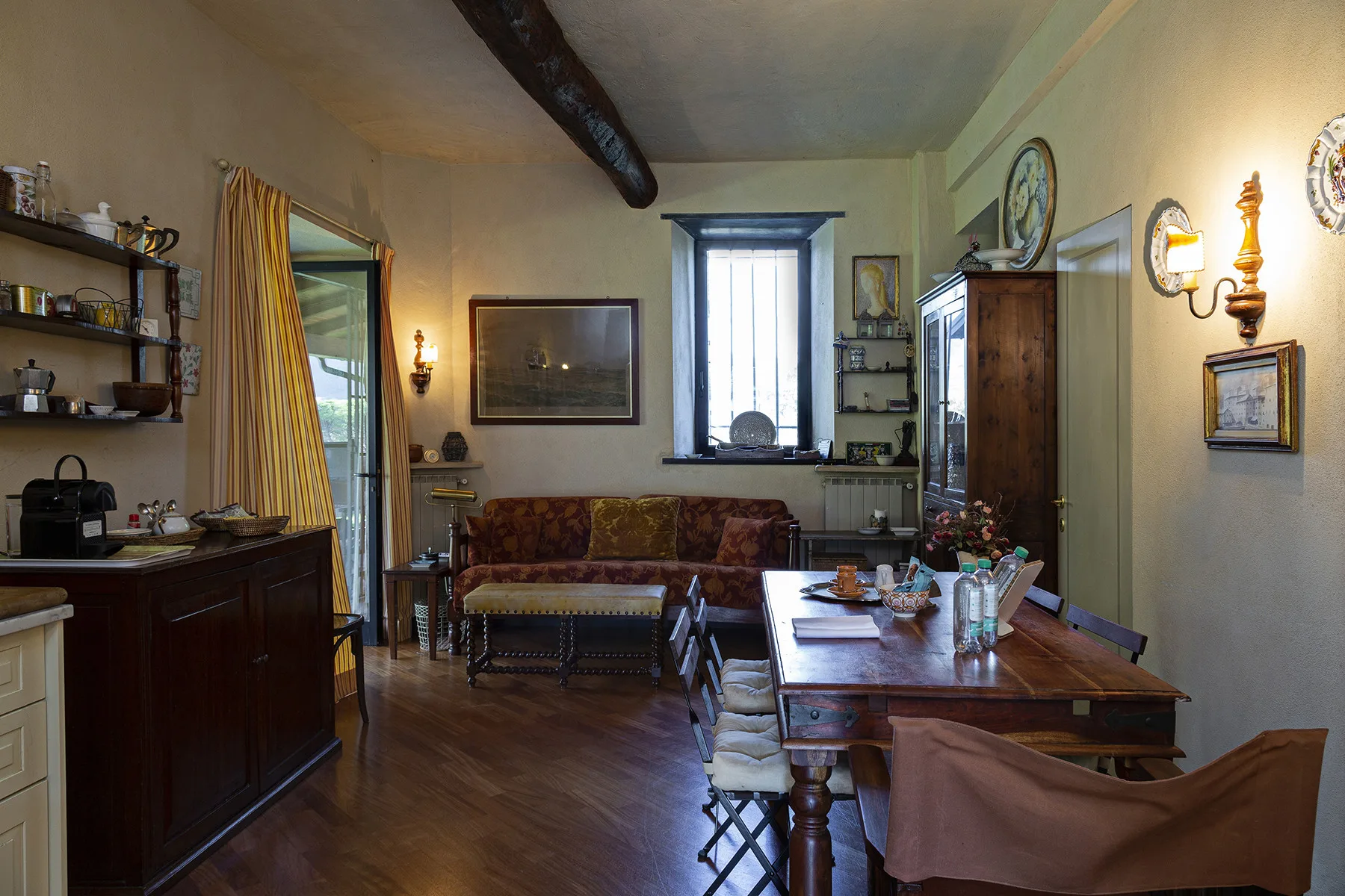 Una sala de estar y comedor con una mesa de madera y asientos alrededor.