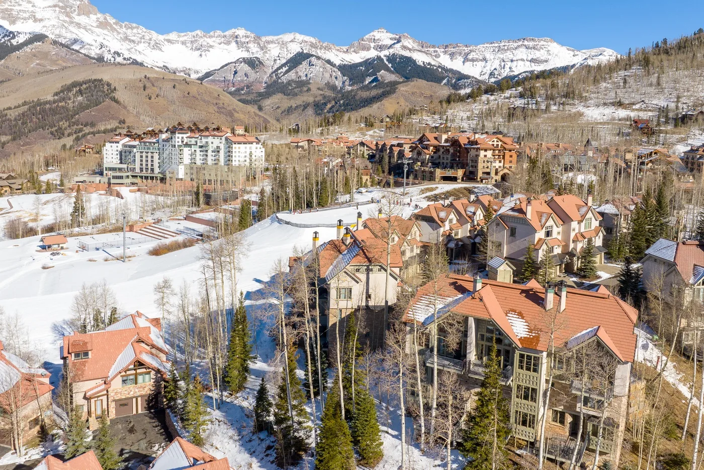 A snow-dusted mountain village with clustered homes beneath a broad snowy range.