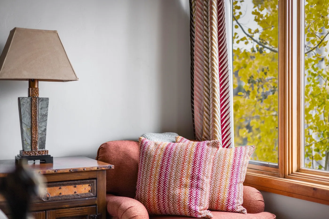 A sitting area with a cushioned seat beside a large window.