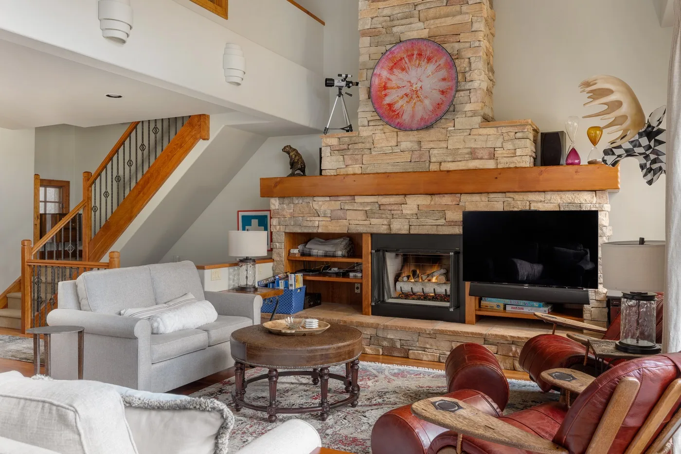 A living room with a stone fireplace, television, and seating.