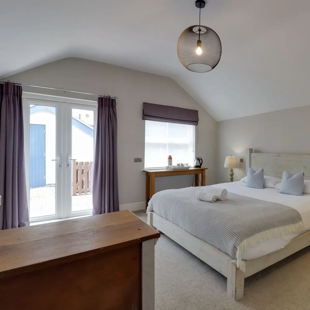 Ground-floor bedroom with French doors opening onto a private patio.