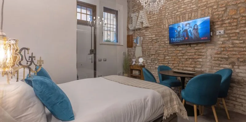 Un dormitorio con una cama y una pequeña zona de estar junto a una pared de ladrillo.