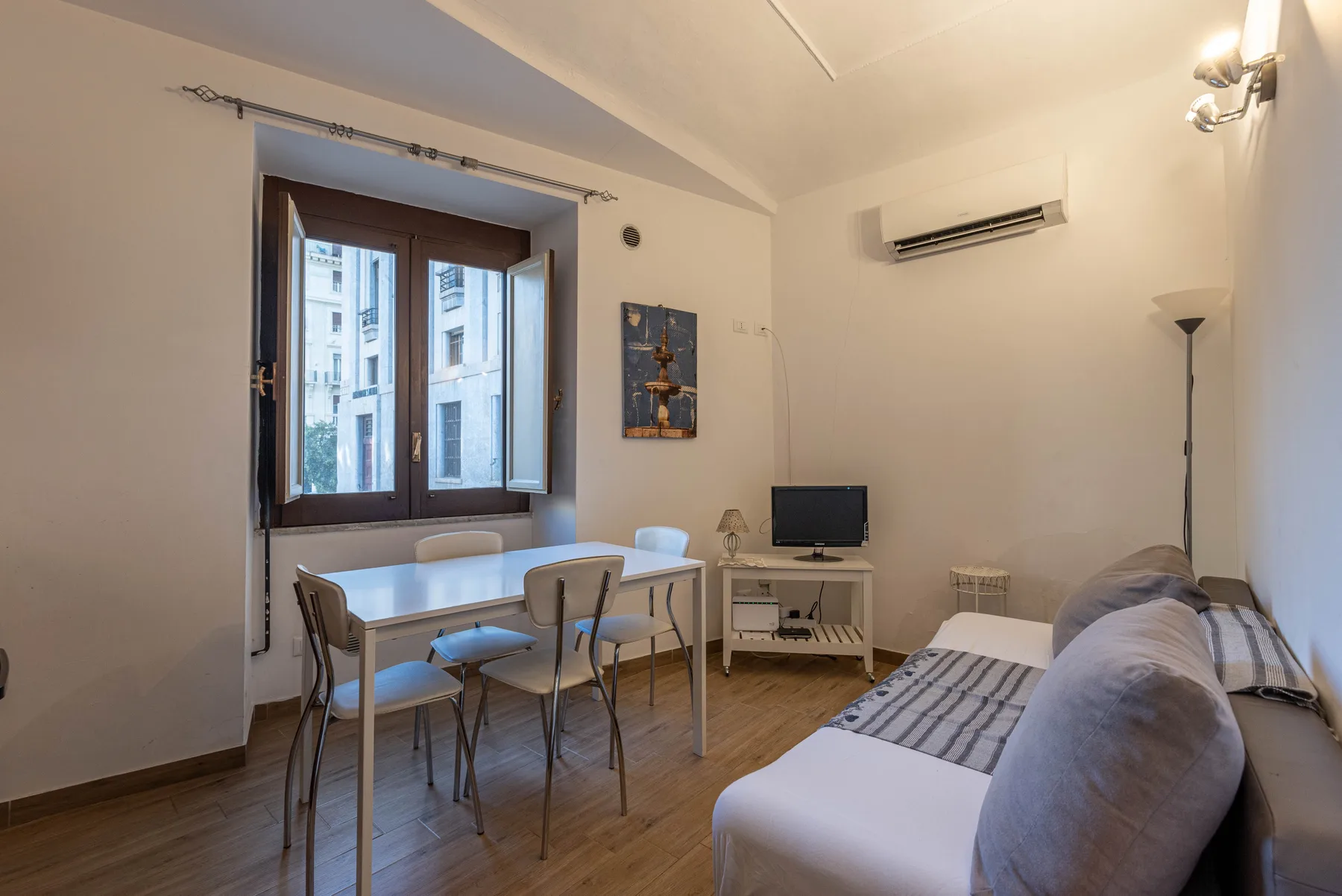 A living area with a dining table beside a window and seating.