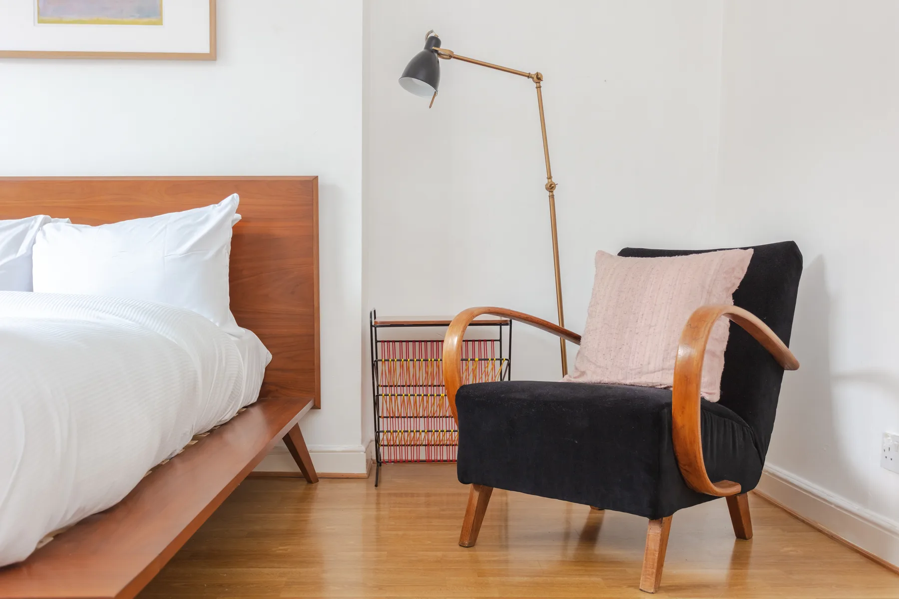 A bedroom seating area with a cushioned armchair beside the bed.