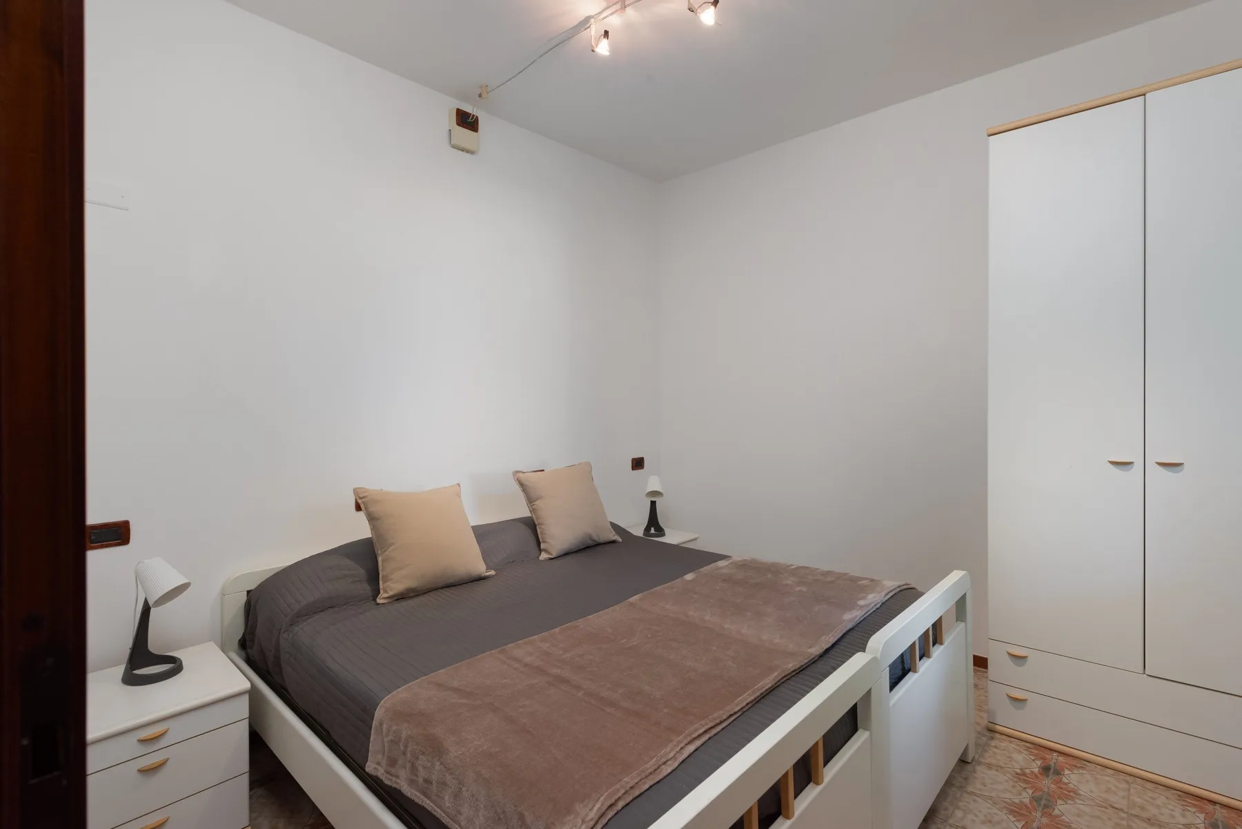 Un dormitorio con una cama, una mesita de noche y un armario empotrado.