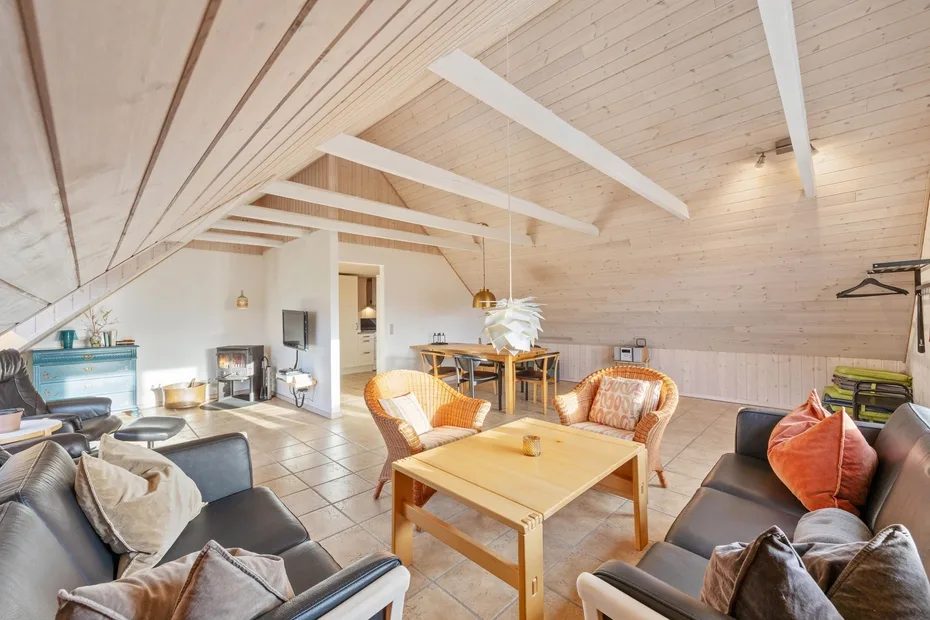 Una sala de estar luminosa con asientos alrededor de una mesa de centro de madera.