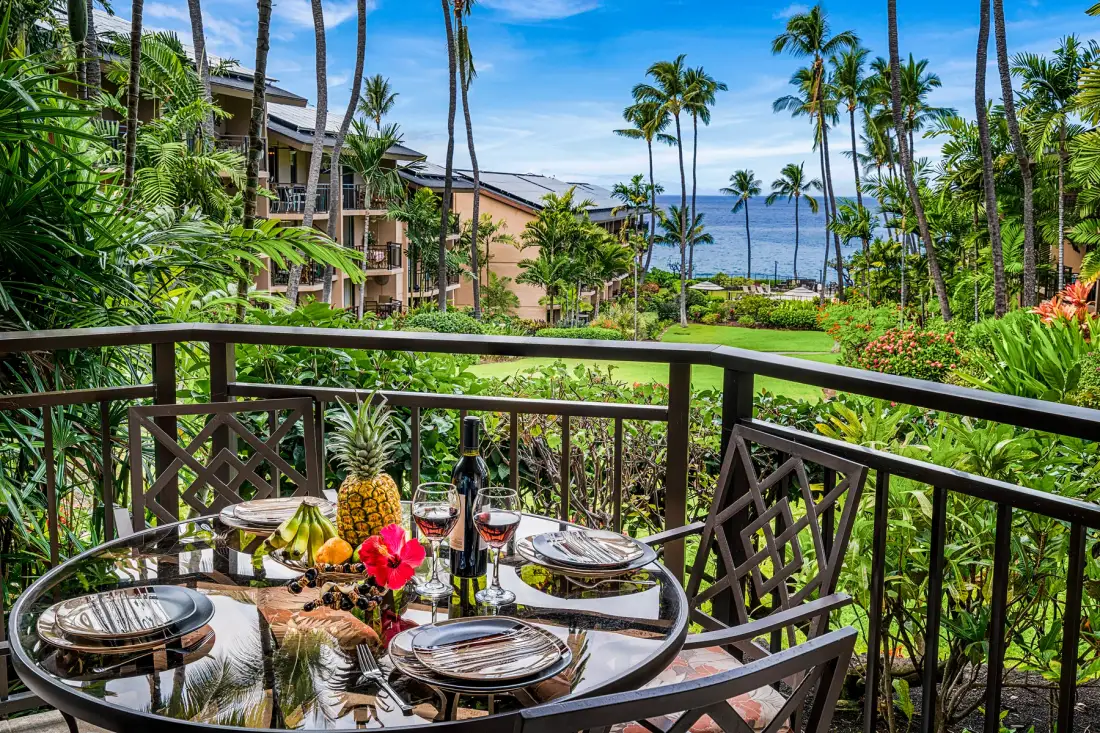 Un comedor en el balcón da a jardines tropicales y al océano.