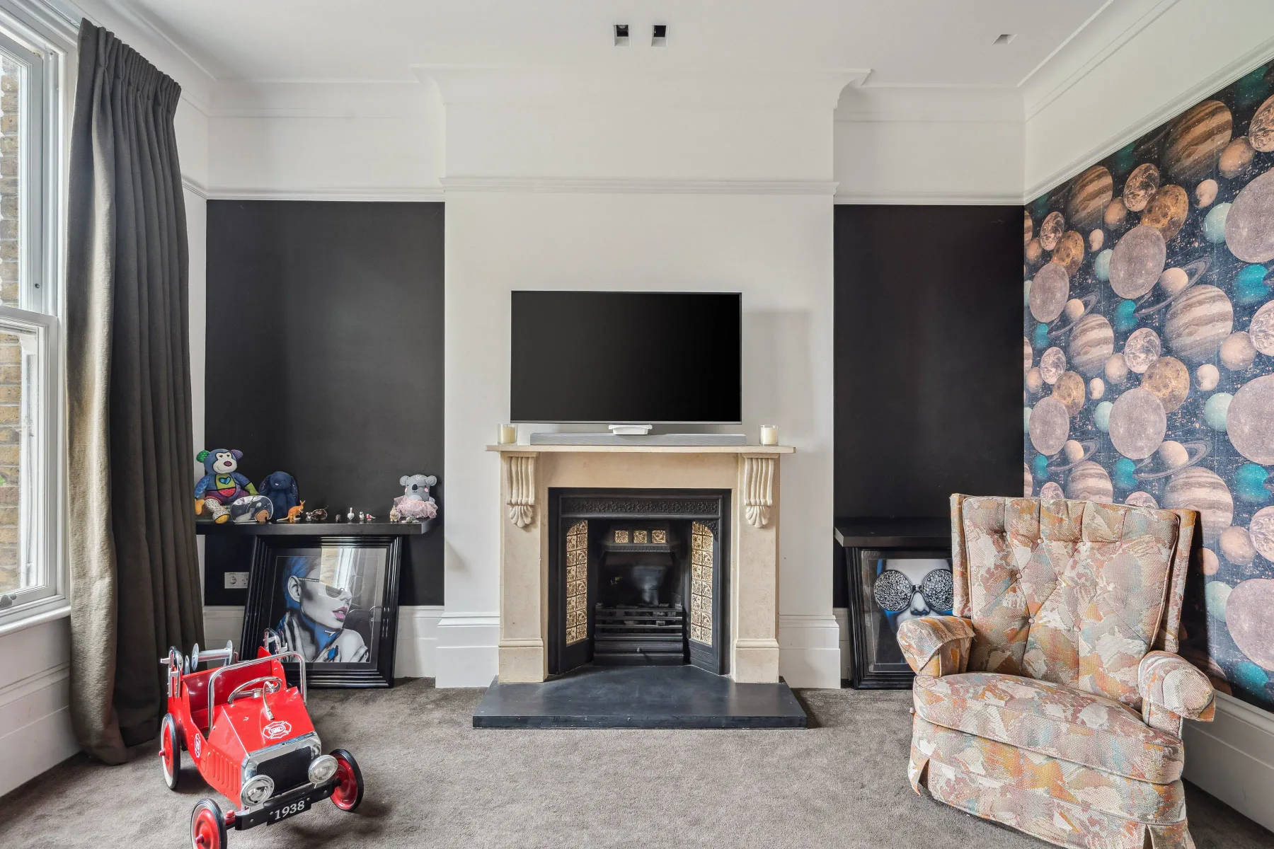 Sala de estar con chimenea, televisor y una pared decorativa estampada.