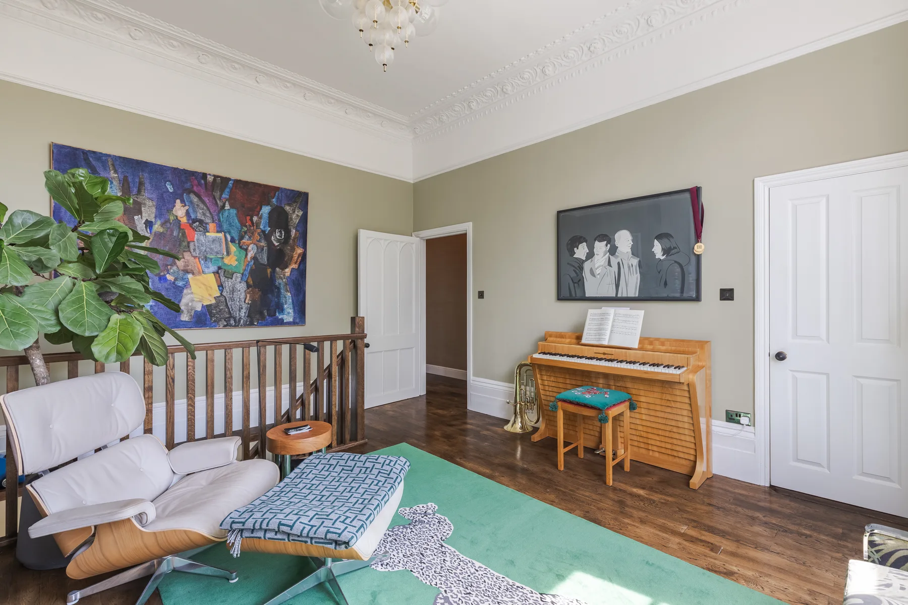Una sala de estar con asientos, un piano y coloridas obras de arte en las paredes.