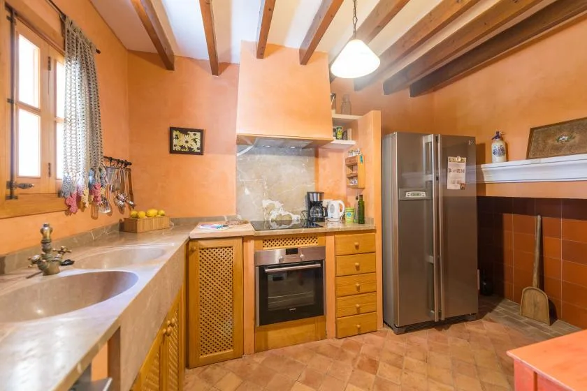 A warm-toned kitchen with a countertop, sink, and cooking area.
