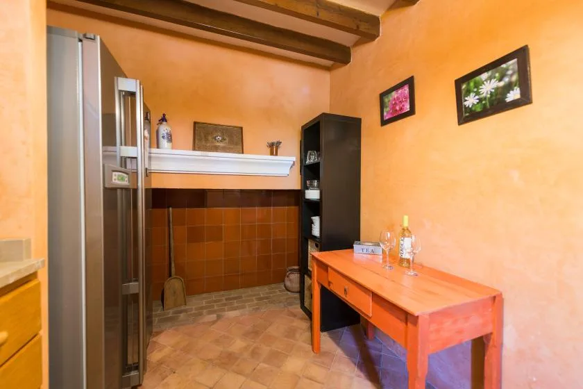 A warm-toned room with a tiled fireplace and a wooden table.