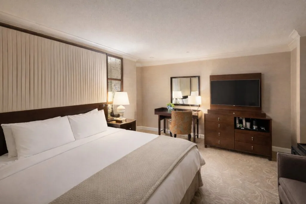 Dormitorio con cama king, escritorio y televisor