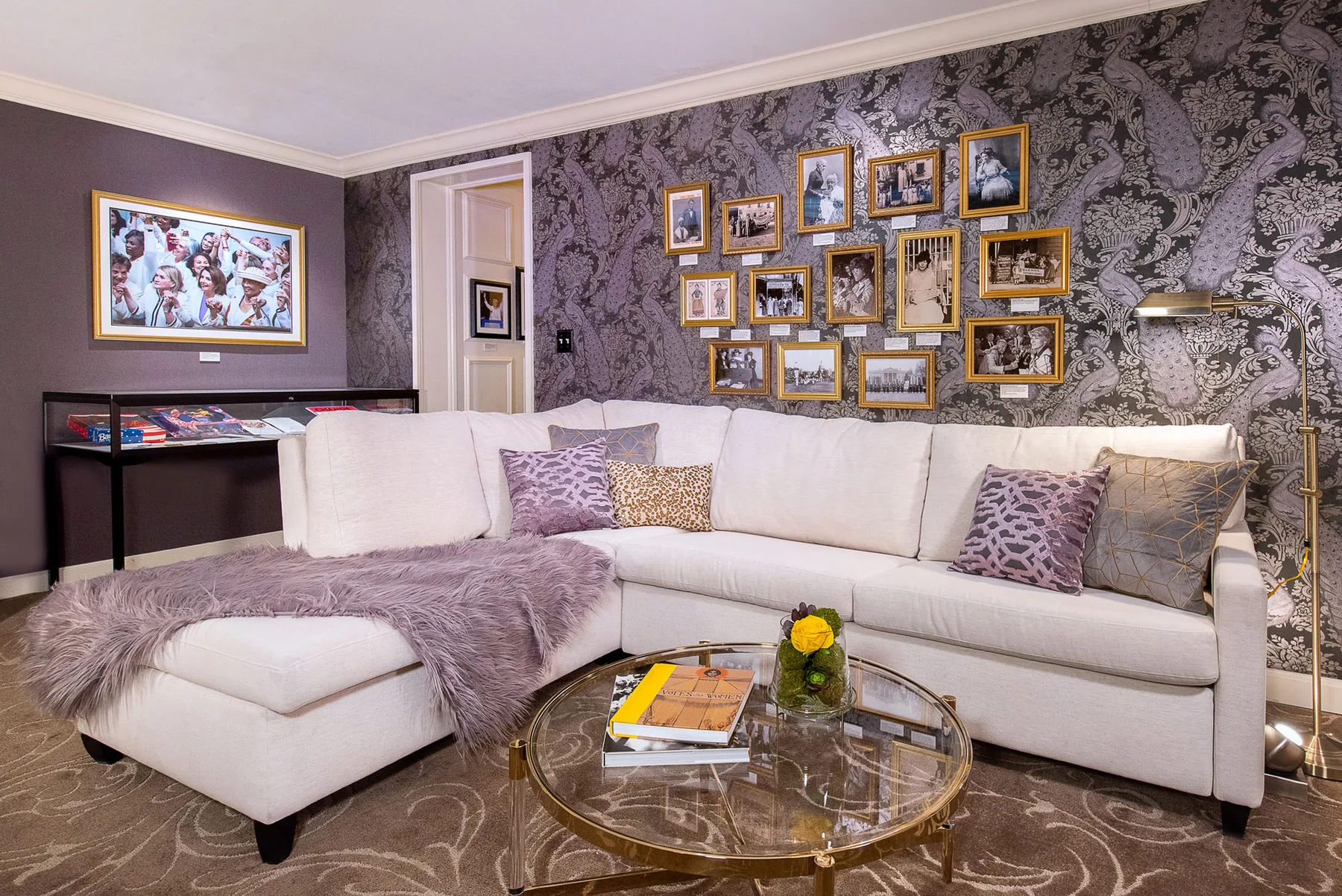 Sala de estar de la Suffrage Suite con sofá modular y obras de arte enmarcadas
