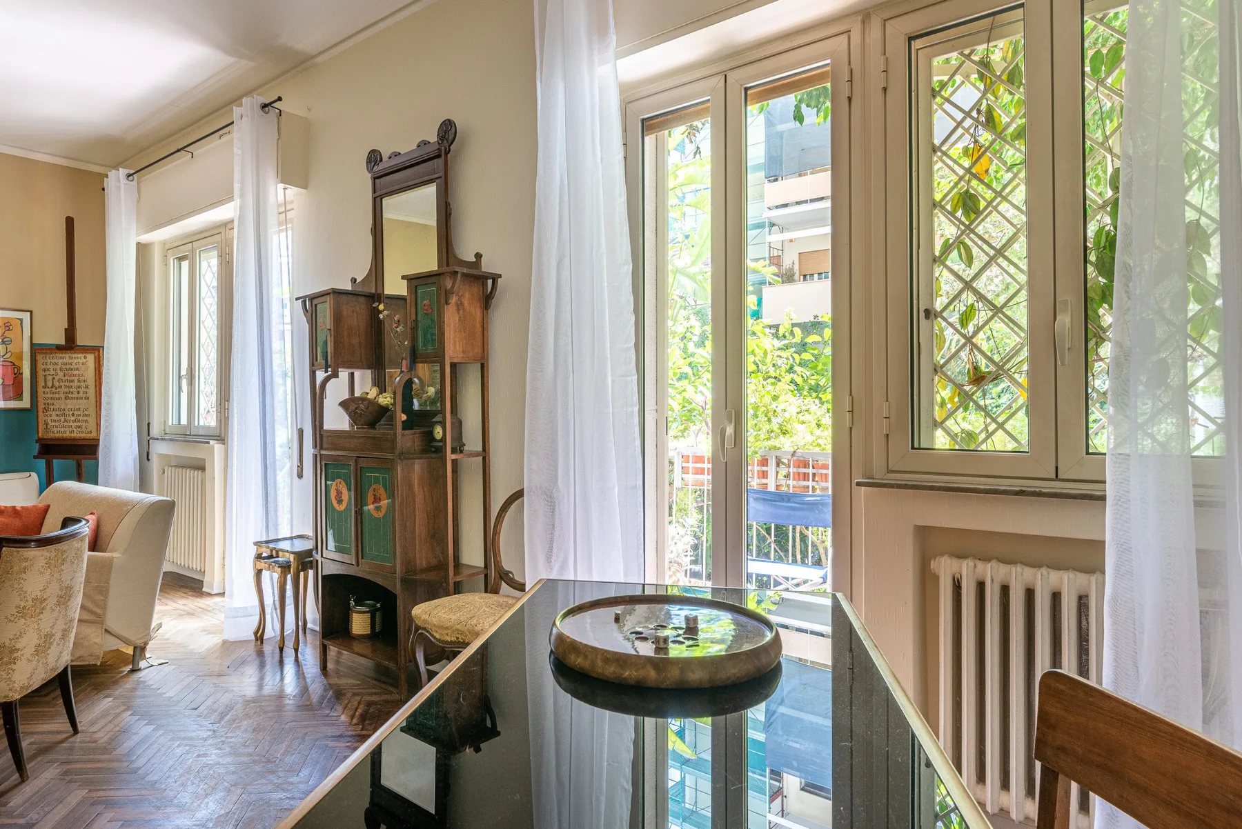 Un salón comedor luminoso con ventanales y una mesa con tapa de cristal.