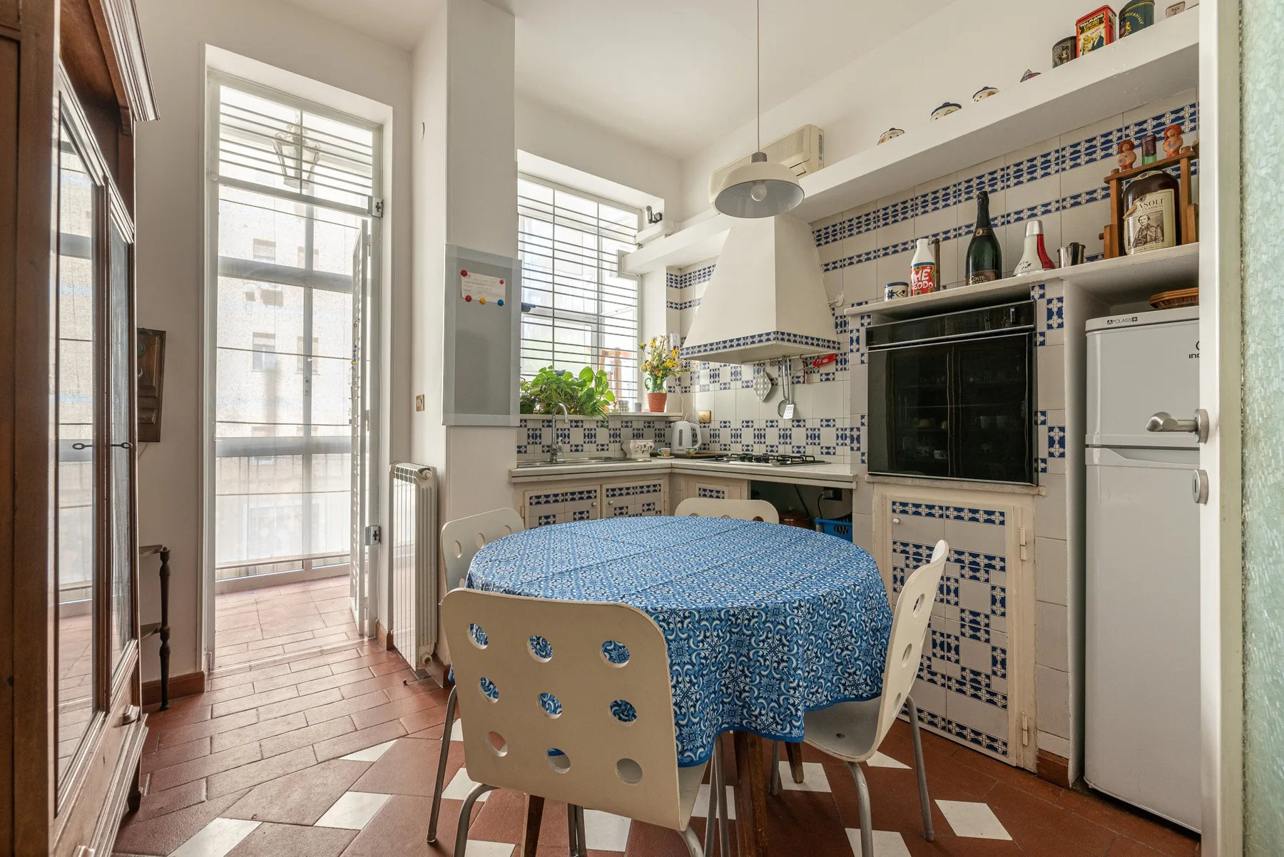 Una zona de comedor en la cocina con una mesa redonda y encimeras de azulejos.