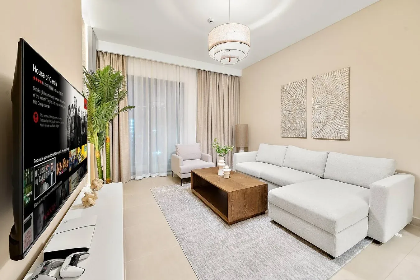 A bright living room with a white sectional sofa, coffee table, and curtained windows.