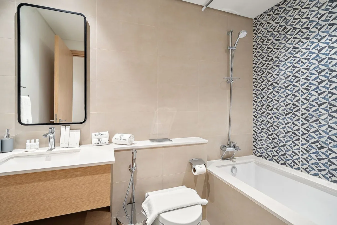 A tiled bathroom with a bathtub, shower, sink, and toilet.