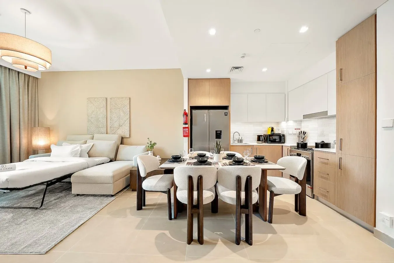 An open-plan living and dining area with a kitchen in the background.