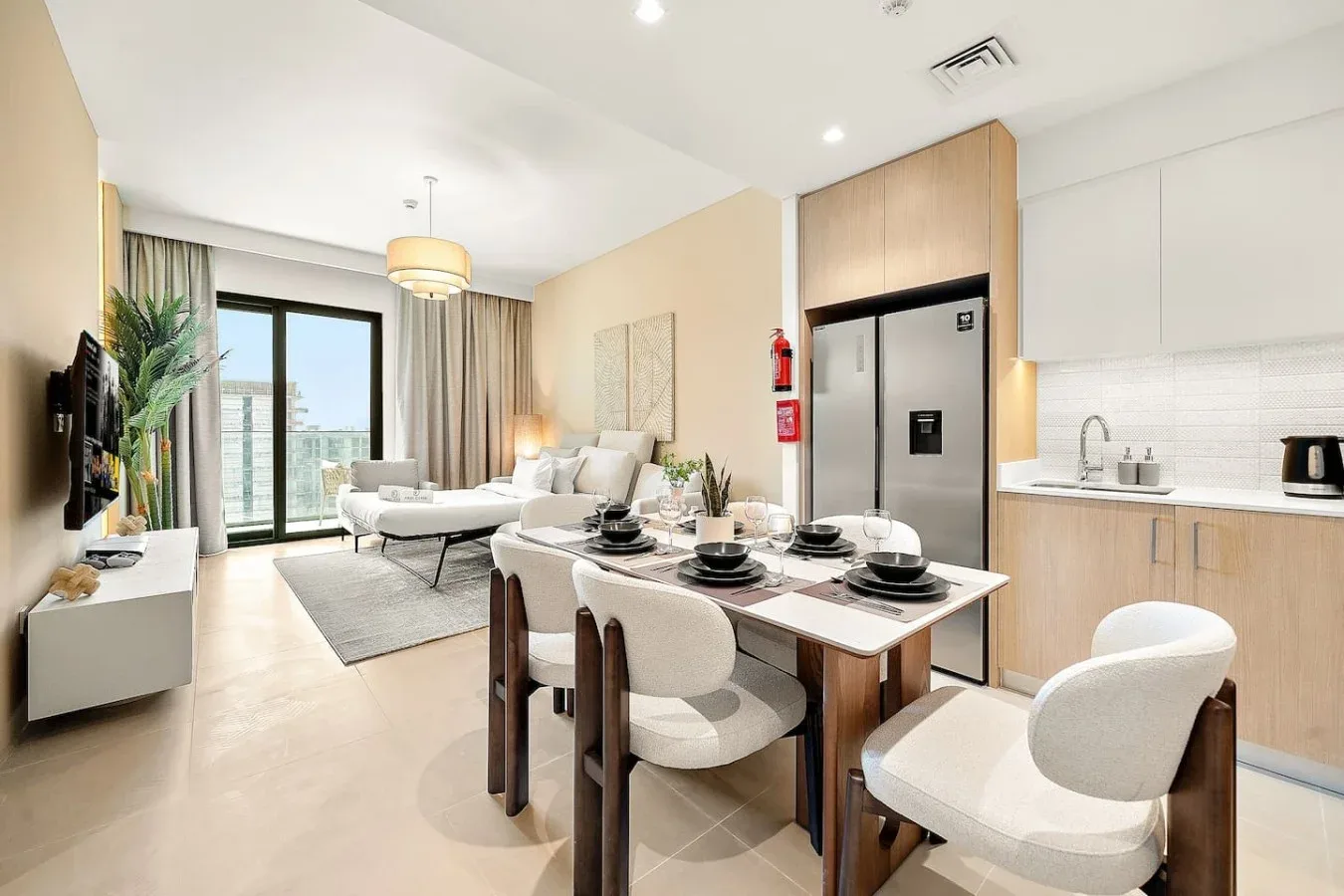 An open-plan living and dining area with a kitchen and large windows.