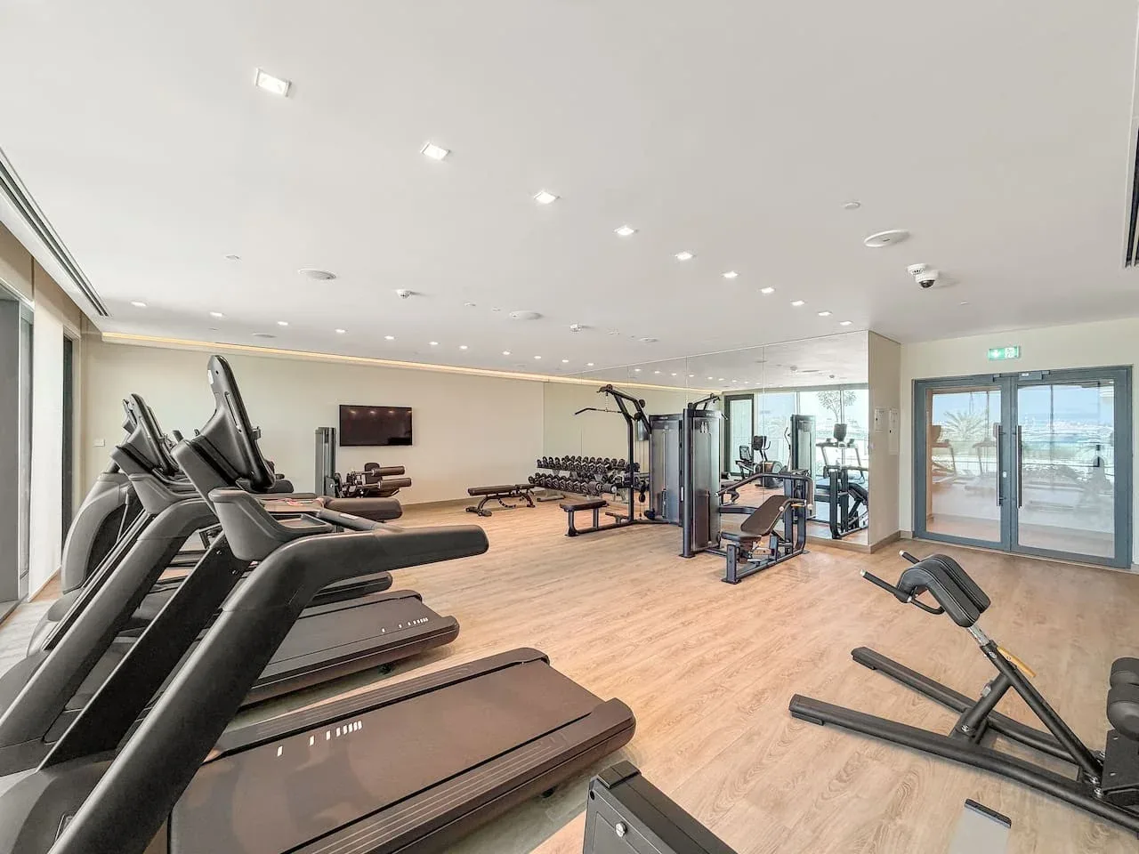 A gym with treadmills, exercise bikes, and weight-training equipment.