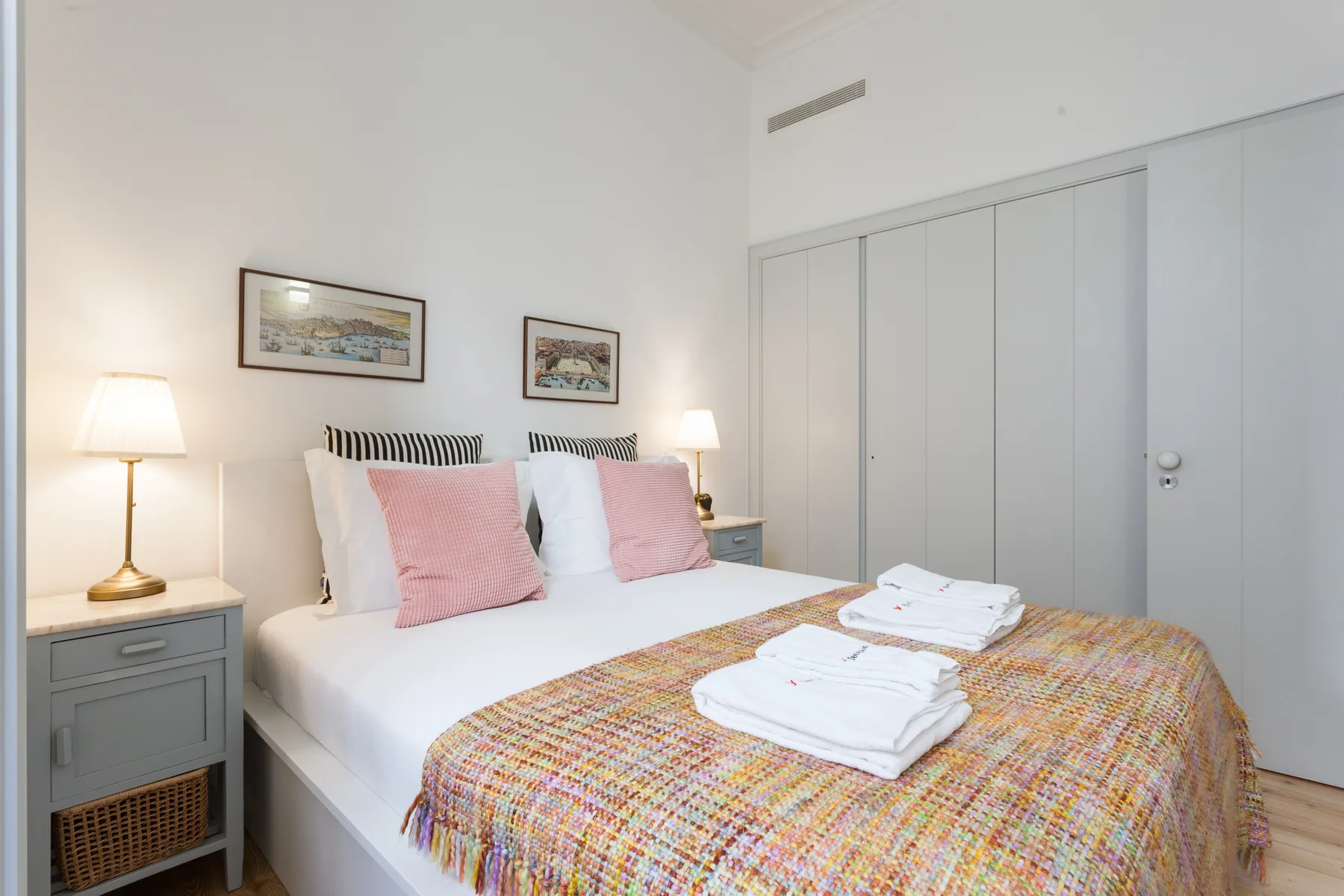 Un dormitorio con una cama bien hecha y una colcha tejida de colores.