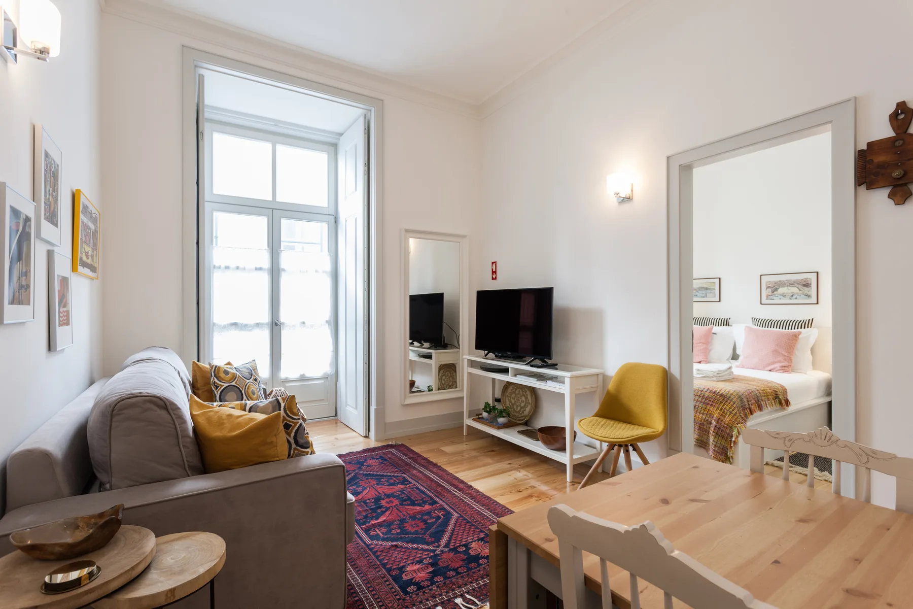 Sala de estar con asientos, un televisor y una mesa de comedor.