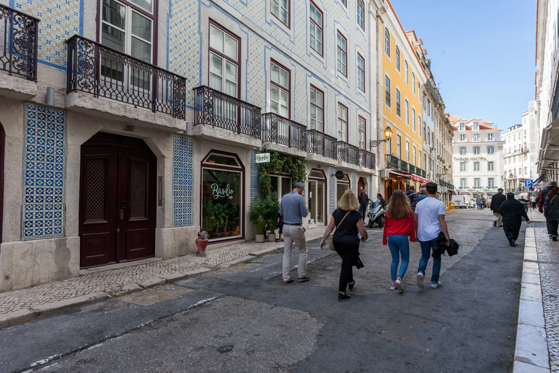Una calle peatonal flanqueada por edificios con azulejos y pequeños balcones.