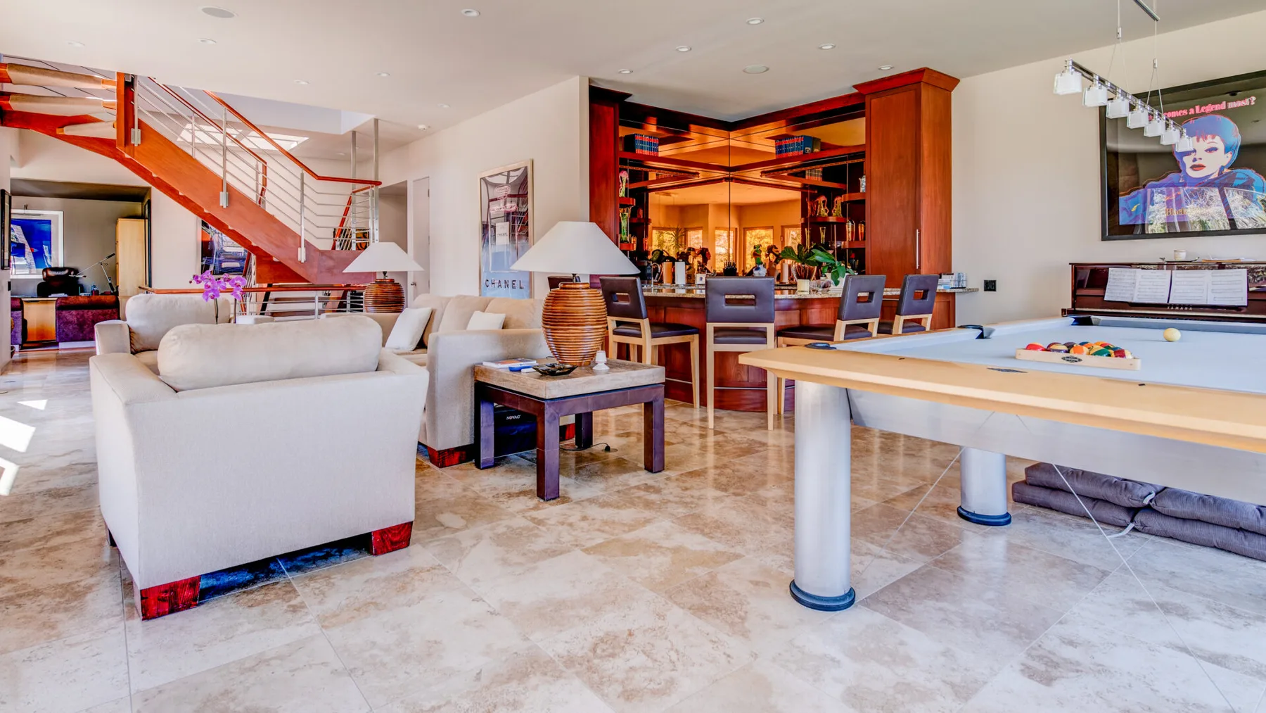 Una sala diáfana y luminosa con asientos, una mesa de billar y una zona de bar.
