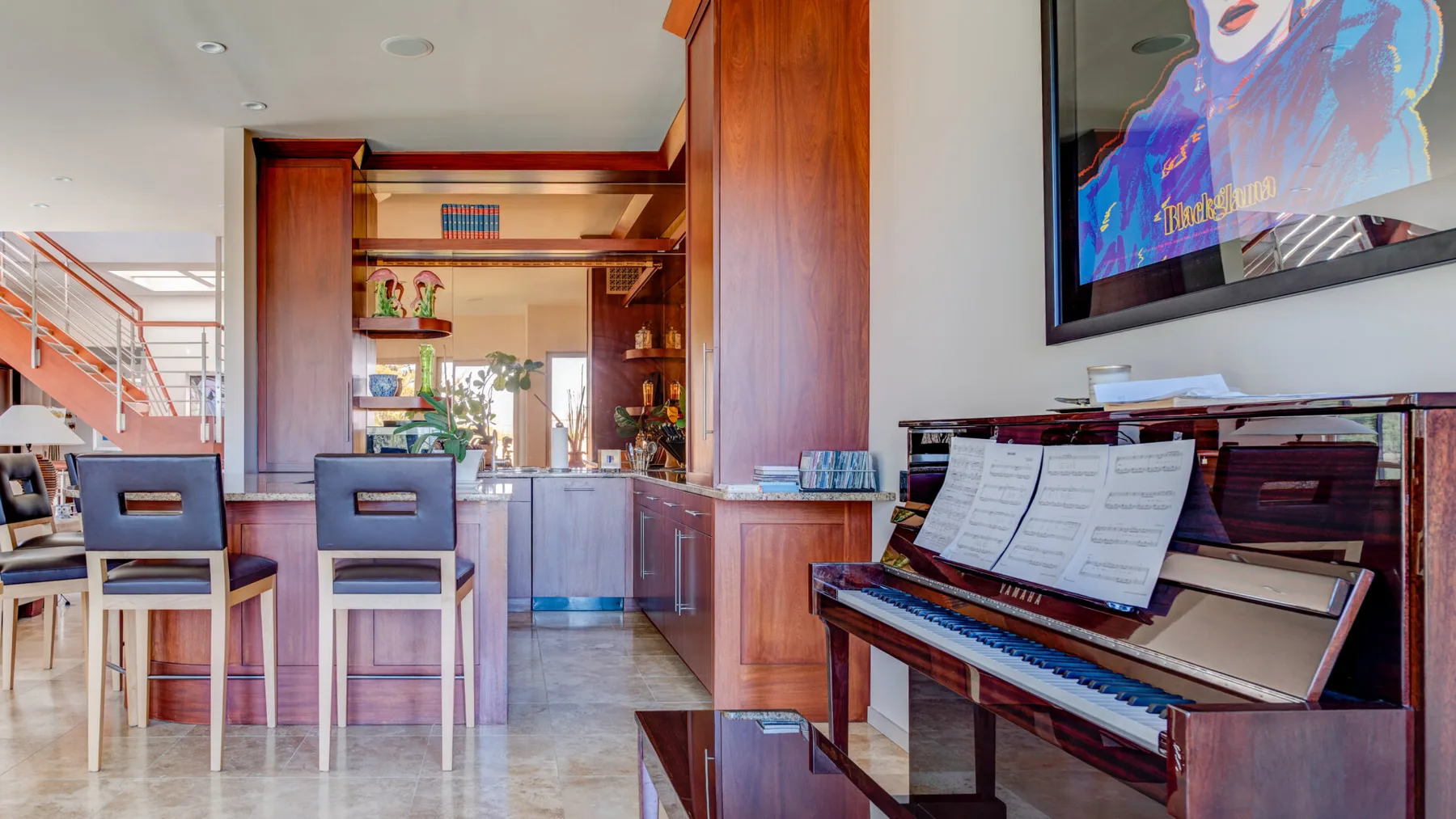 Una cocina moderna y zona de comedor con un piano junto a la barra.