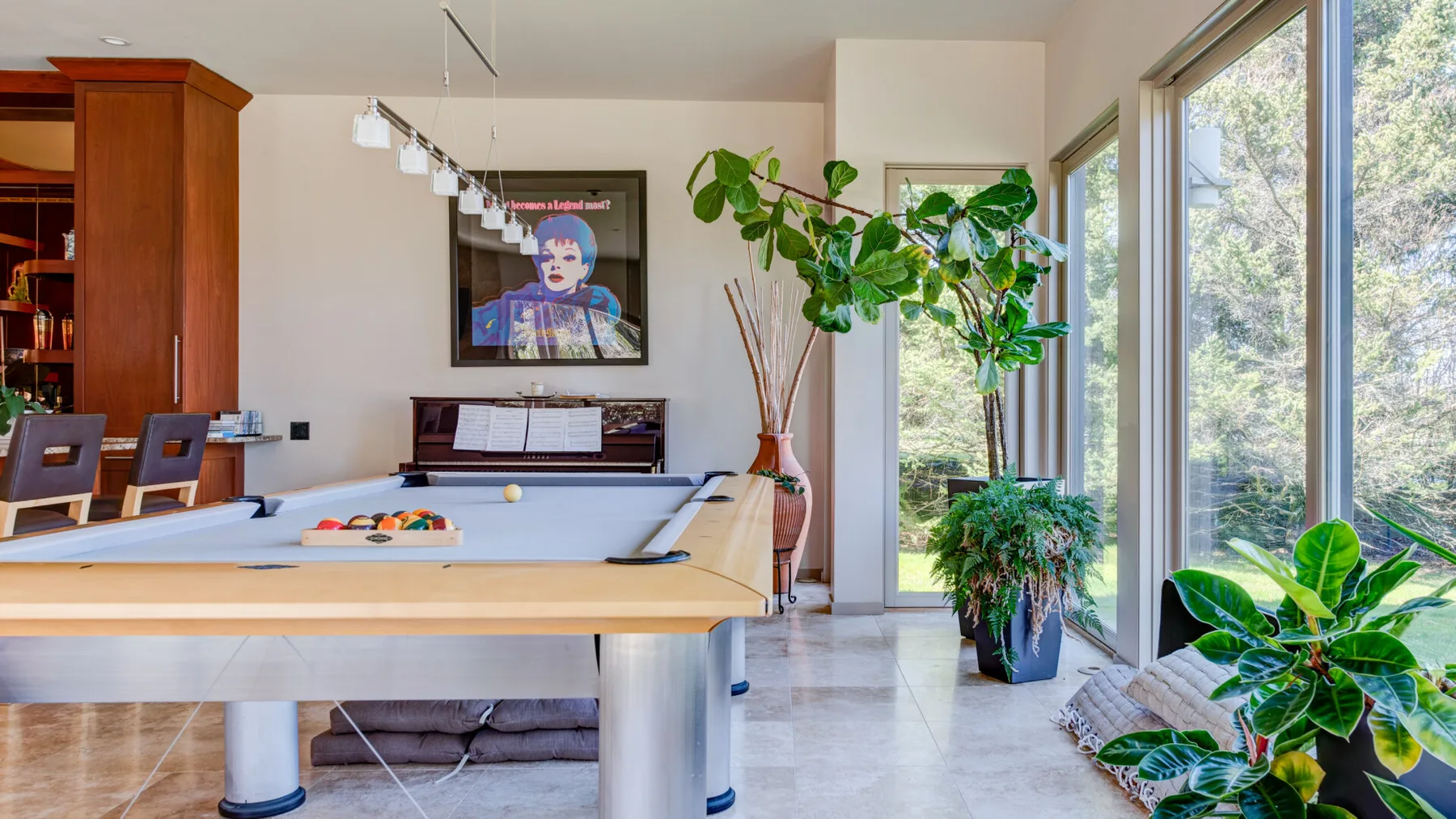 Una luminosa sala de juegos con una mesa de billar y grandes ventanas.