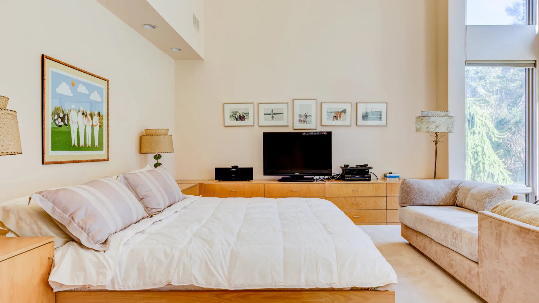 Un dormitorio con una cama, un televisor y una zona de estar.