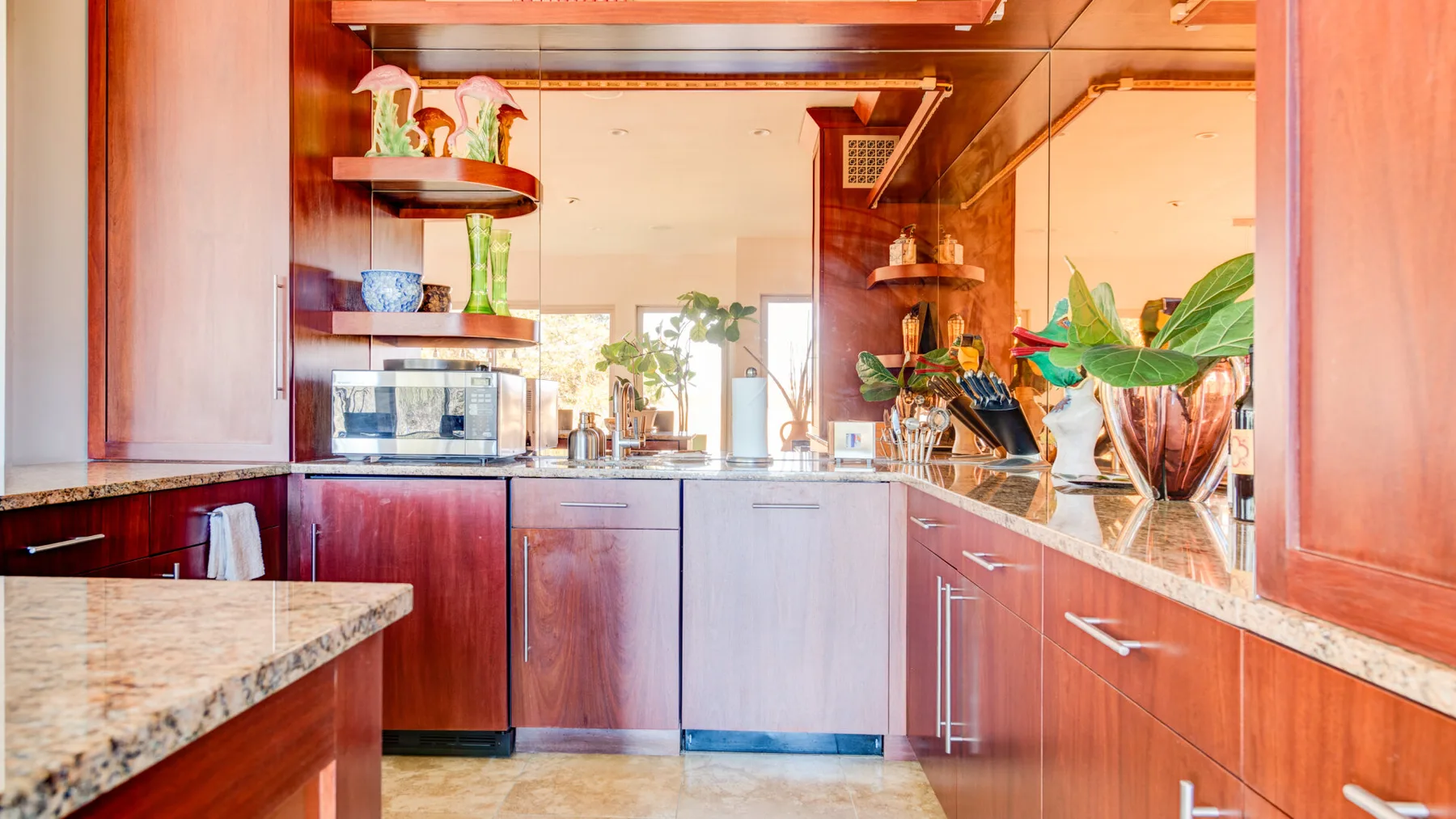 Una cocina con gabinetes de madera, encimeras de piedra y un fregadero.