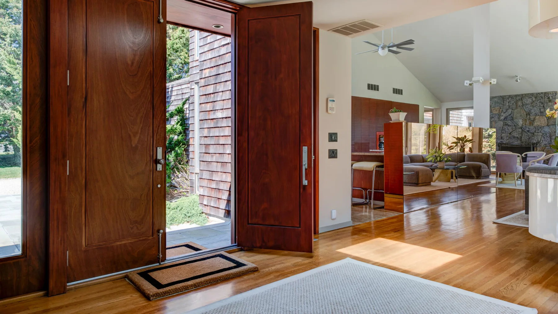 Una entrada abierta da paso a una luminosa sala de estar con piso de madera.