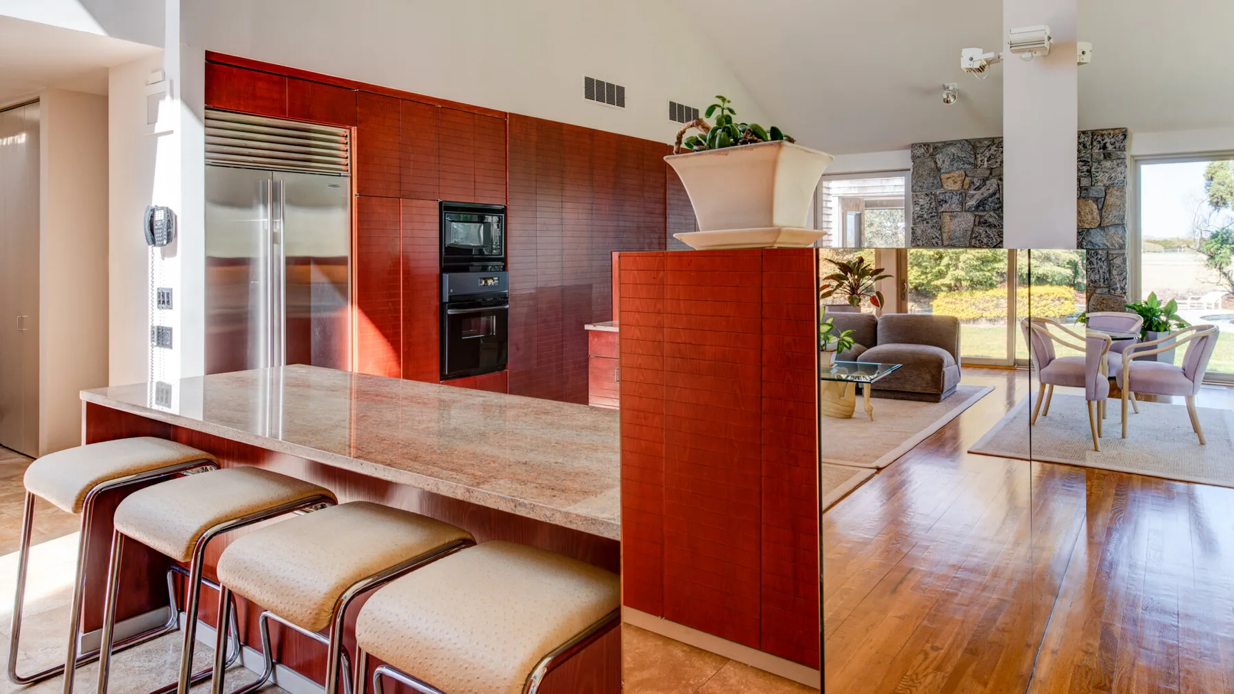 Cocina y comedor de planta abierta con una barra larga y asientos.
