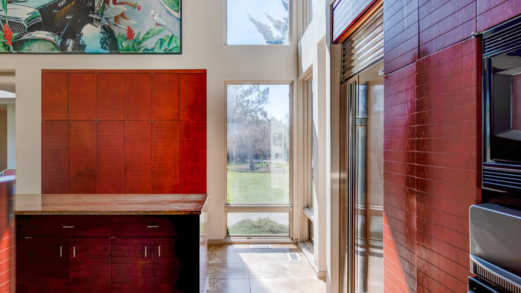 Un interior luminoso con paneles de madera rojos, gabinetes y ventanas altas.