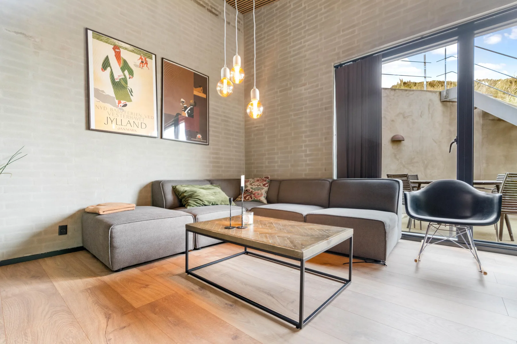 Una sala de estar con asientos seccionales y una mesa de centro junto a puertas de vidrio.