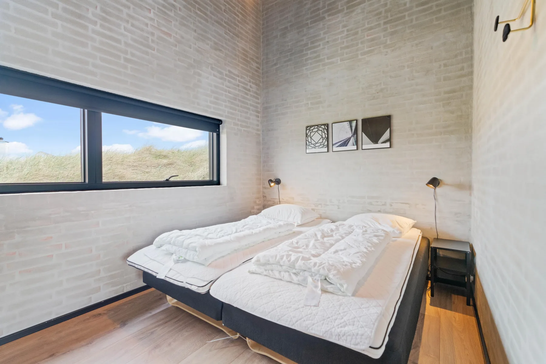 Un dormitorio con dos camas bajo una ventana amplia.