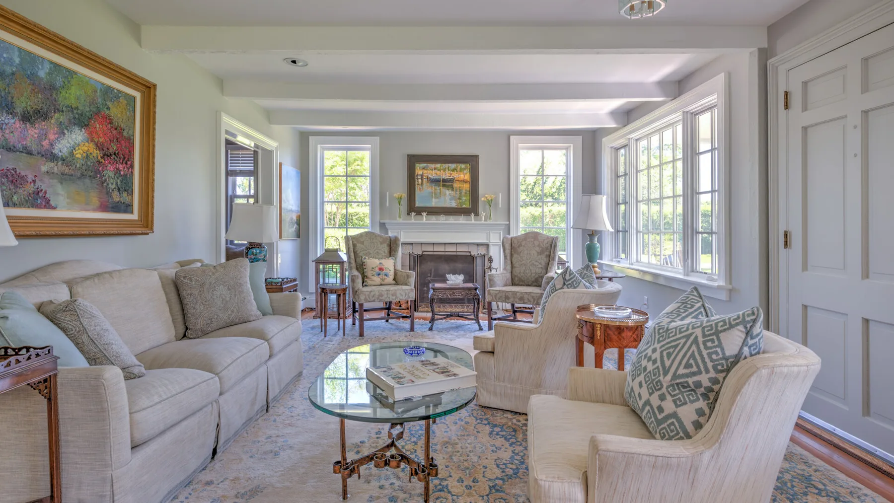 A bright living room with seating arranged around a glass coffee table.