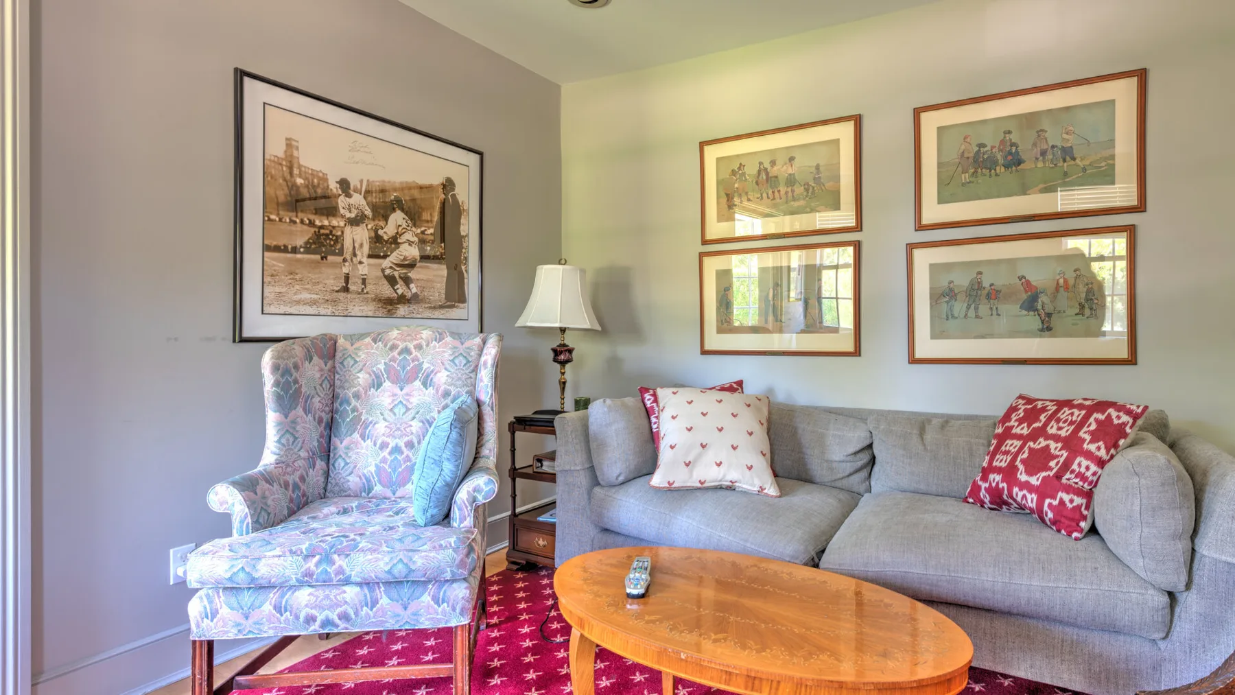 A living room with a gray sofa, patterned armchair, and wooden coffee table.