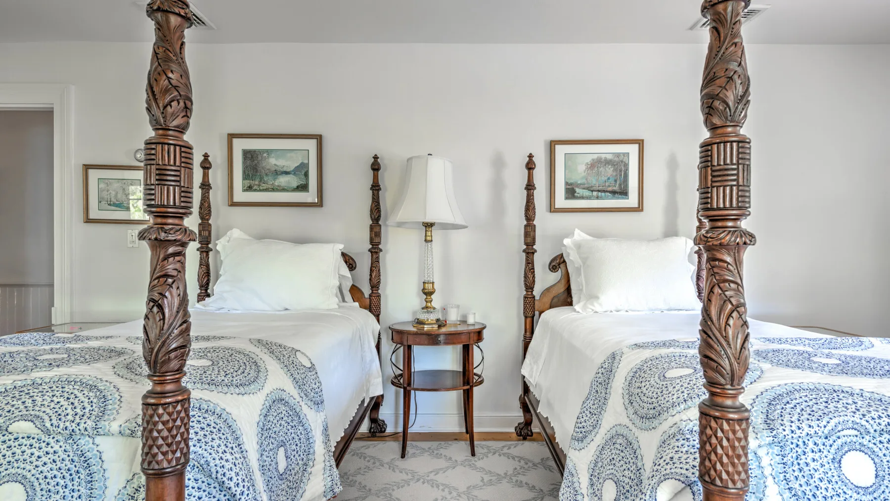 A bedroom with two beds and a small table between them.