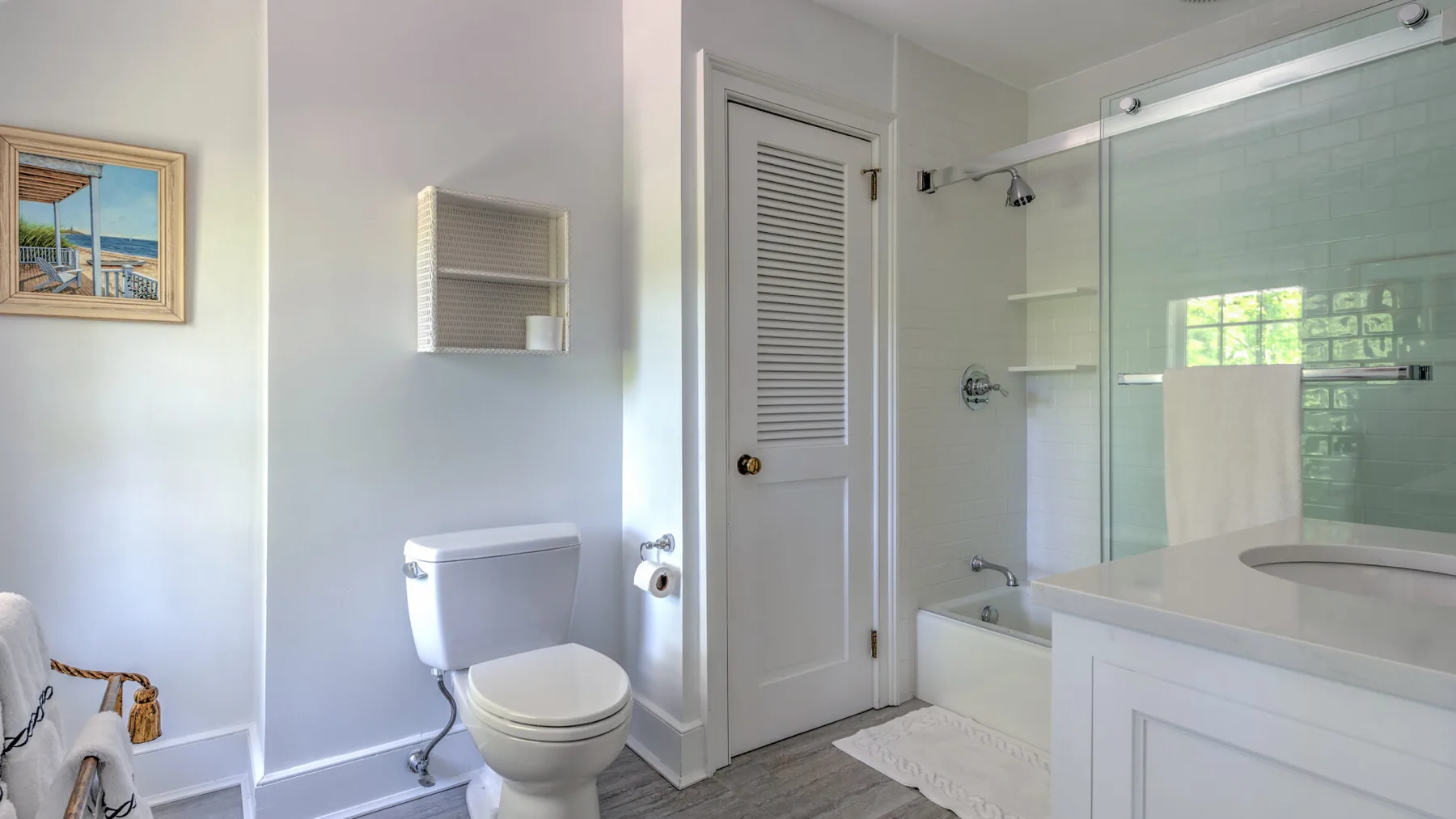 A bathroom with a toilet, sink, and glass-enclosed shower area.