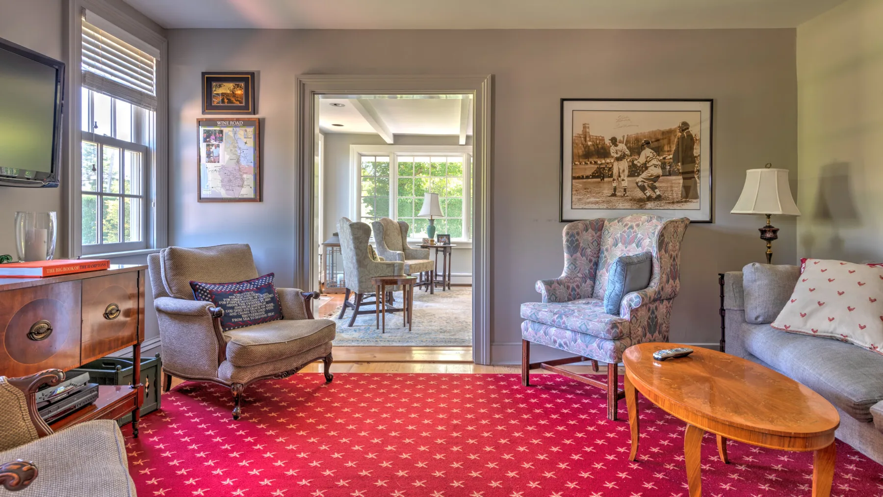 A living room with seating, a wooden coffee table, and windows.