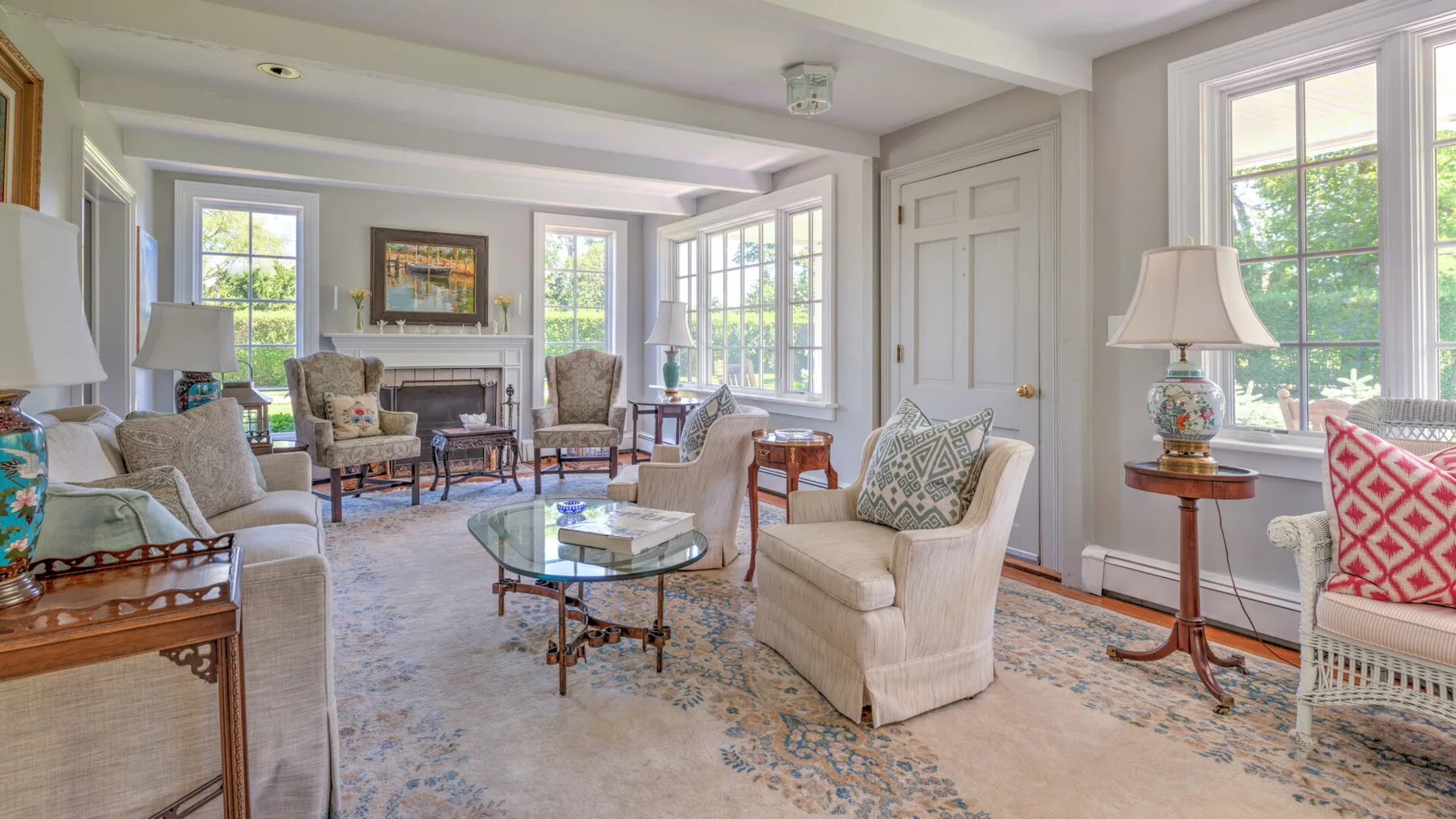 A bright living room with seating arranged around a glass coffee table.