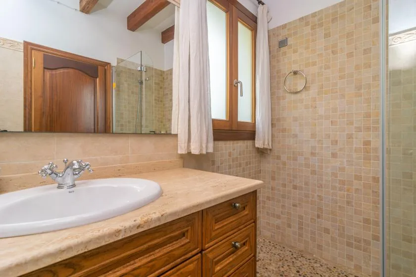 A tiled bathroom with a sink vanity beside the shower.