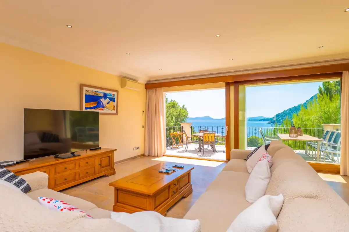 A living room with seating and a sliding glass door opening to a terrace.