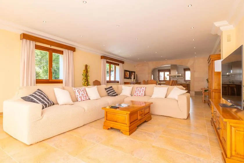 A bright living room with cream seating and a wooden coffee table.