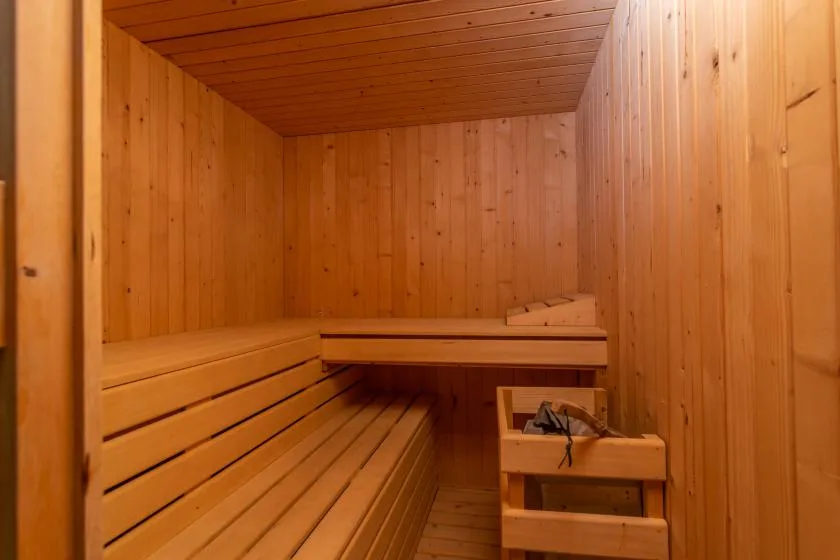 A wood-paneled sauna with tiered wooden seating.