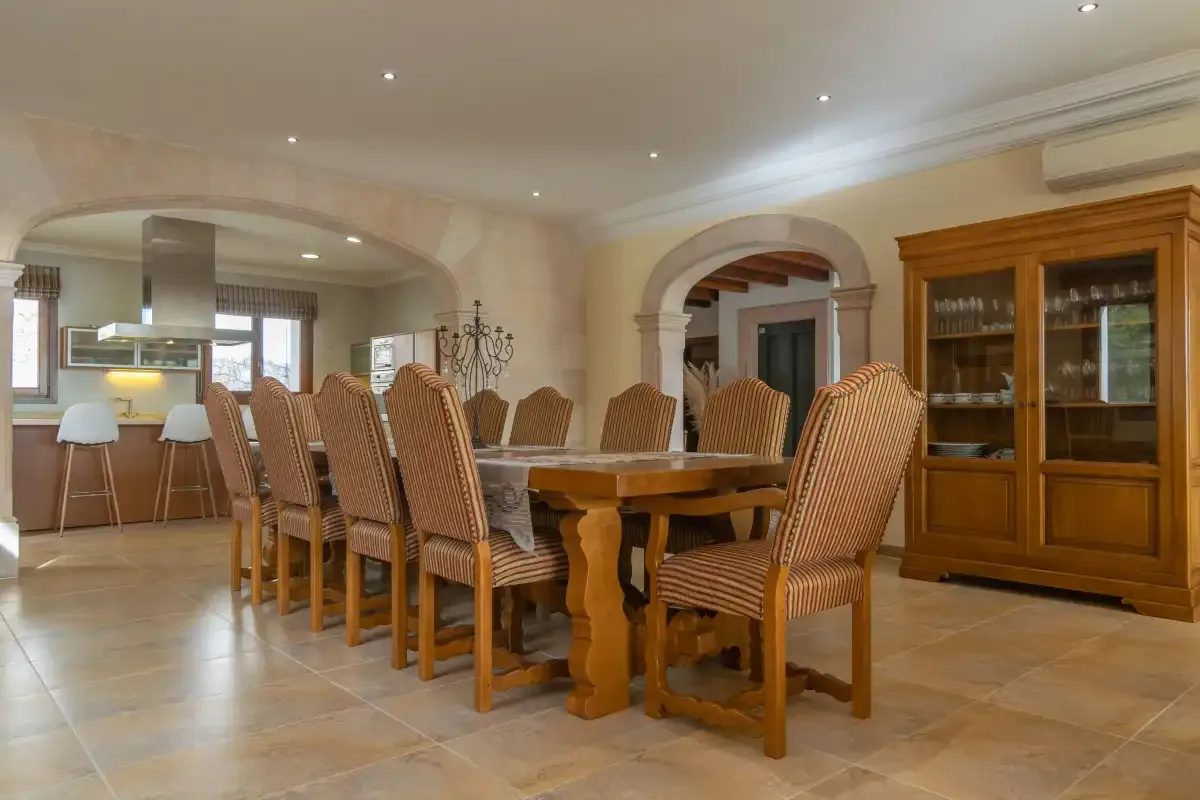 A spacious dining room with a long wooden table and upholstered seating.