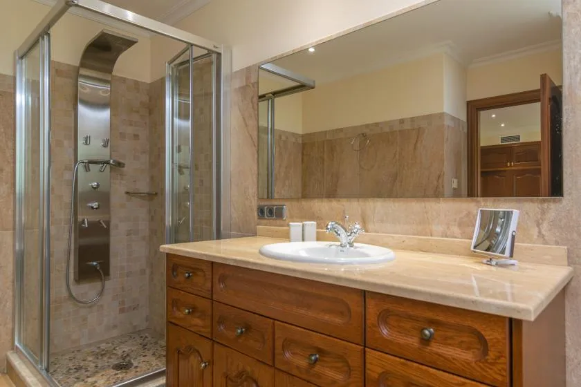 A bathroom vanity with a sink and a glass-enclosed shower.