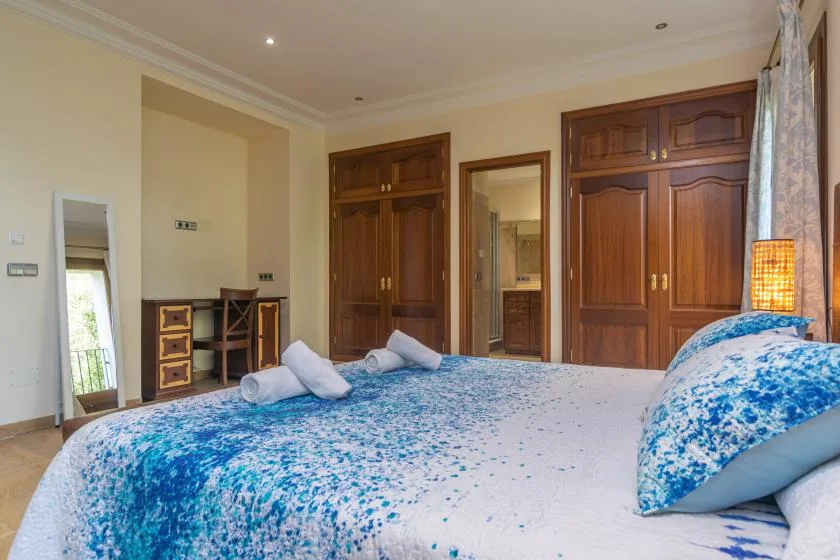 A bedroom with a large bed covered in blue-and-white bedding.
